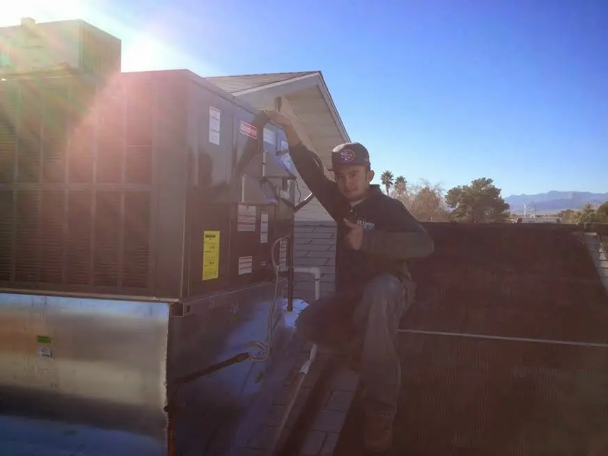 HVAC technician performing AC Tune-Up on a rooftop unit in Delanco